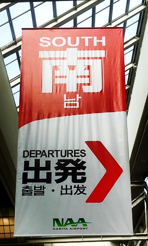 成田空港第2ターミナル出発ロビーにつるされている案内（2017年10月撮影）。“南”が日本語と中国語を表している。